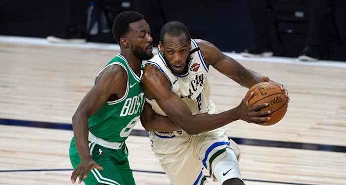 Milwaukee Bucks' Khris Middleton, right, heads to the basket past Boston Celtics' Kemba Walker during the first half of an NBA basketball game Friday, July 31, 2020, in Lake Buena Vista, Fla.